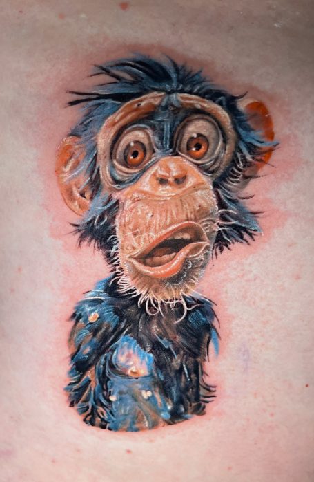 Farbiges Tattoo eines comicartigen Affen mit großen Augen, und ausdrucksstarker Mimik. 
Von Emanuel Melzner
Melzner Exclusive Tattoo Gallery